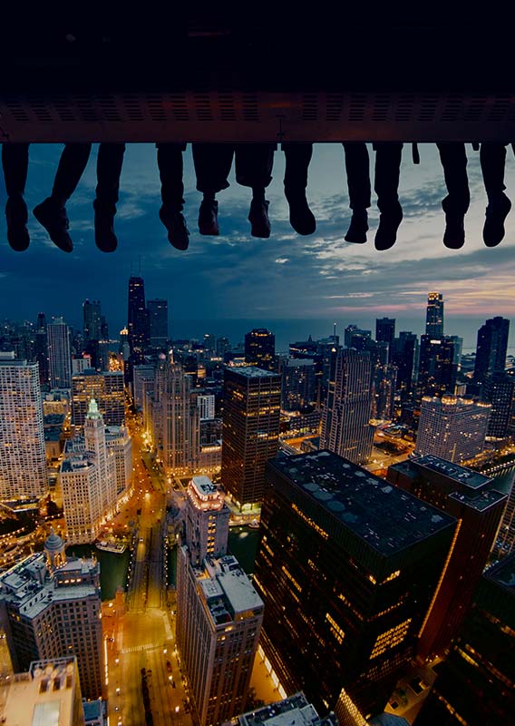 The Chicago city skyline at dusk with riders on a flight ride superimposed.